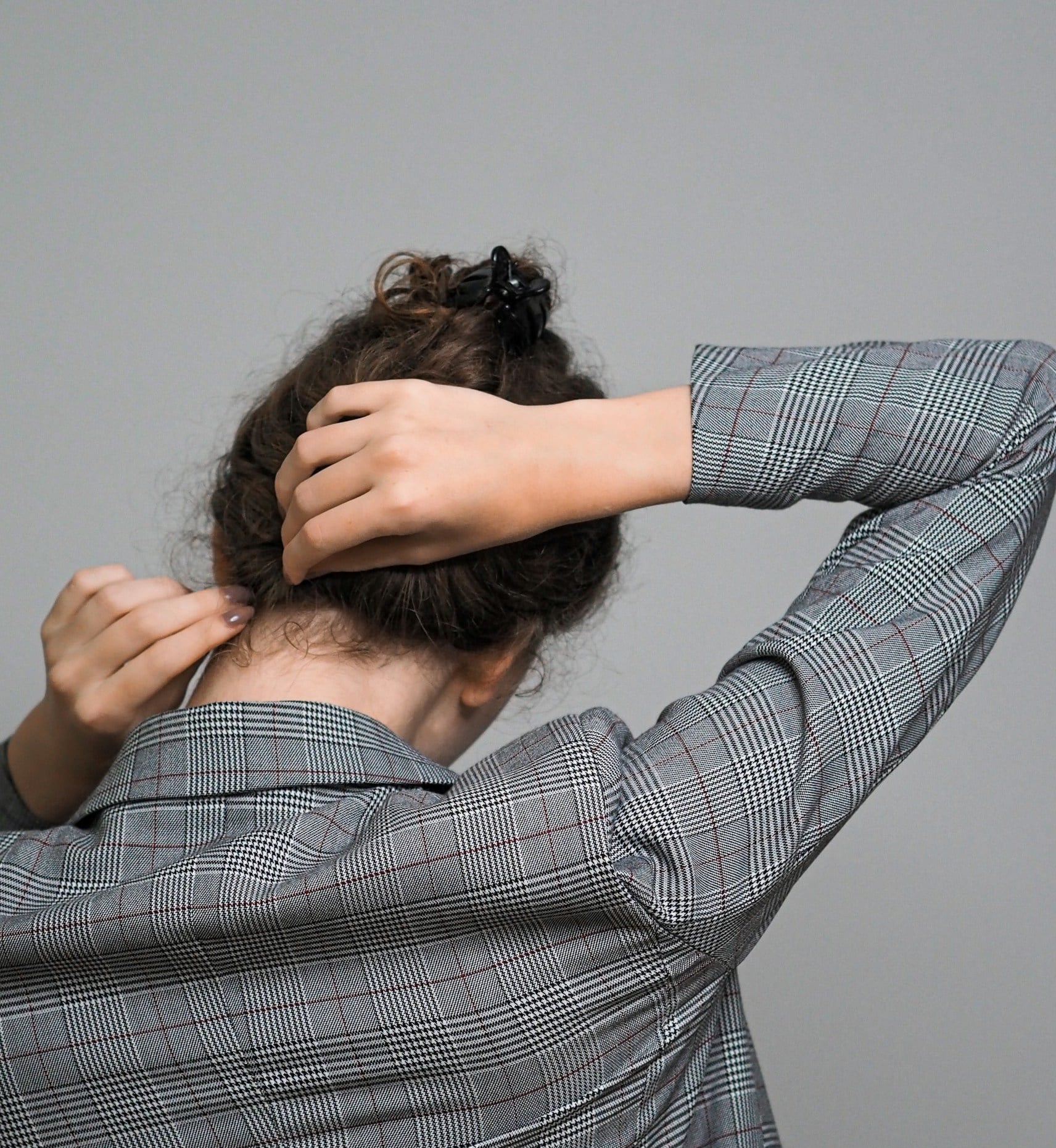 Person from behind touching their hair representing body-focused repetitive behaviours