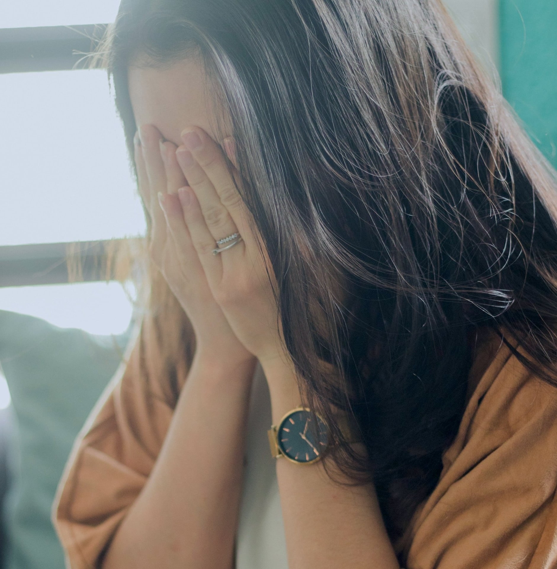 Person with hands covering face representing the distress of OCD